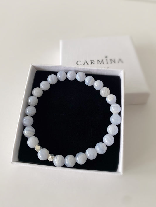 A bracelet with Blue Lace Agate beads and faceted Sterling Silver square spacer beads, presented in a Carmina branded gift box.