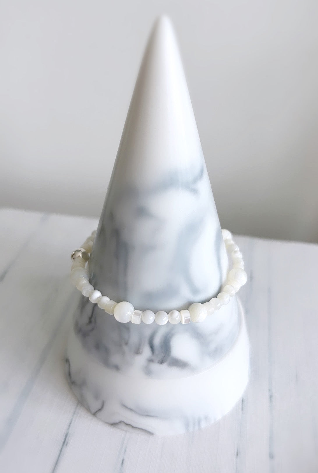 A Mother of Pearl beaded bracelet featuring a gold filled or sterling silver central bead finish.