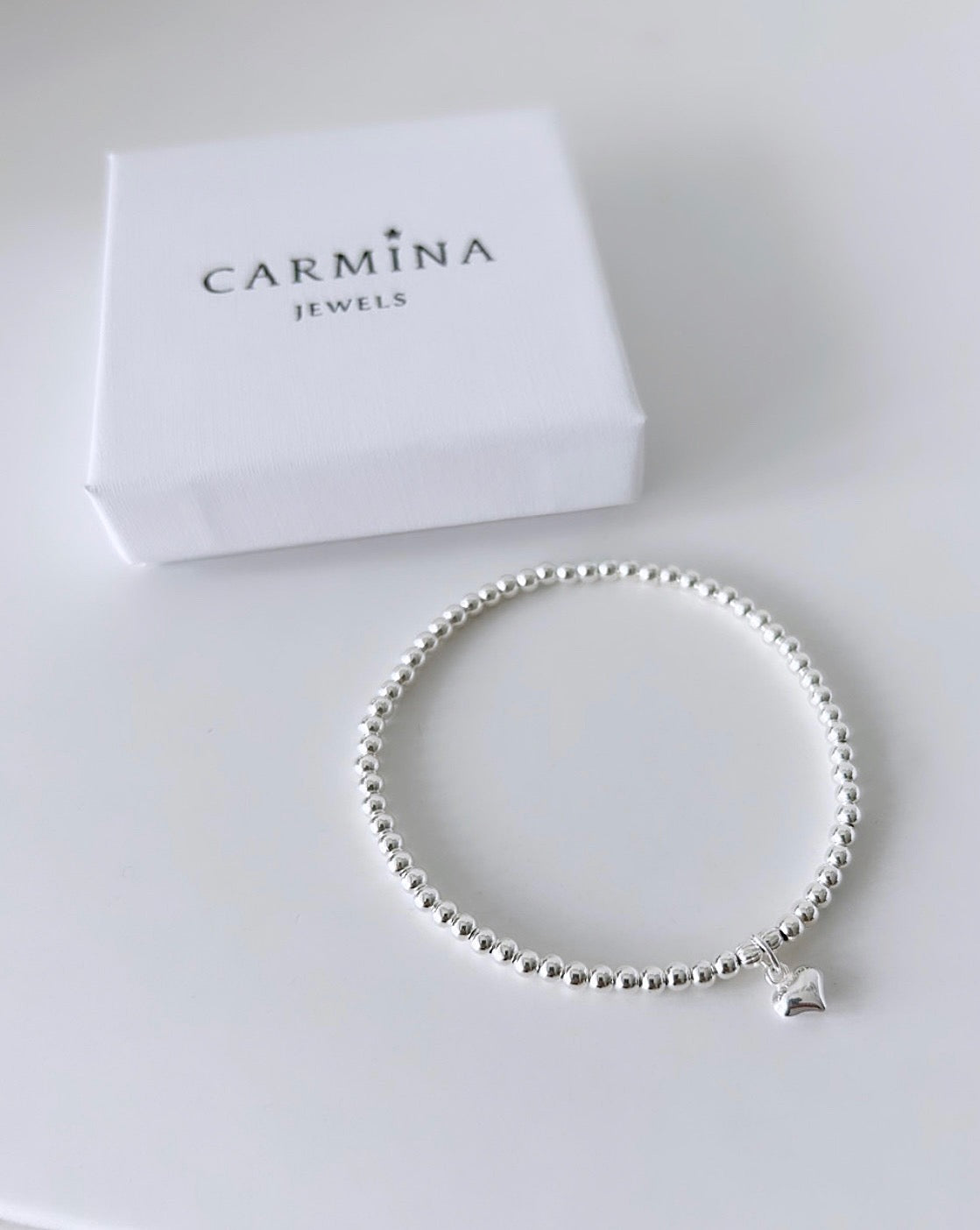 A sterling silver bead bracelet with a small heart charm