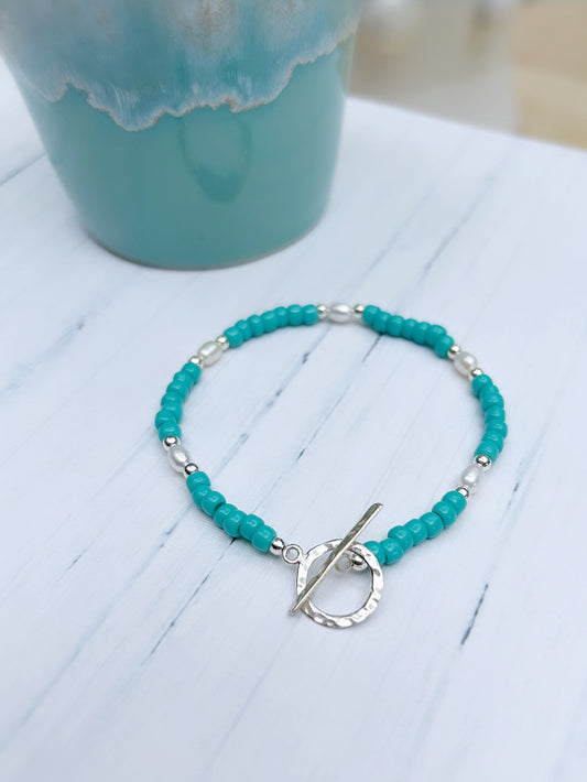 A turquoise glass bead bracelet with sterling silver beads and a sterling silver toggle clasp