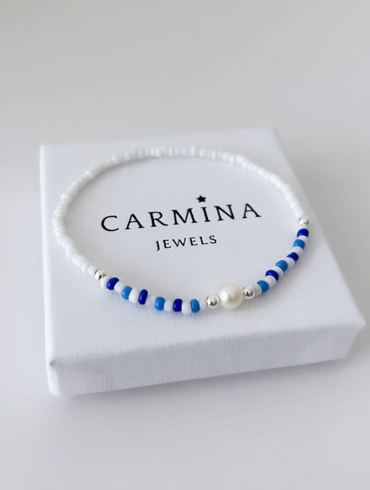 A seed bead bracelet with blue and white beads, and a white freshwater pearl