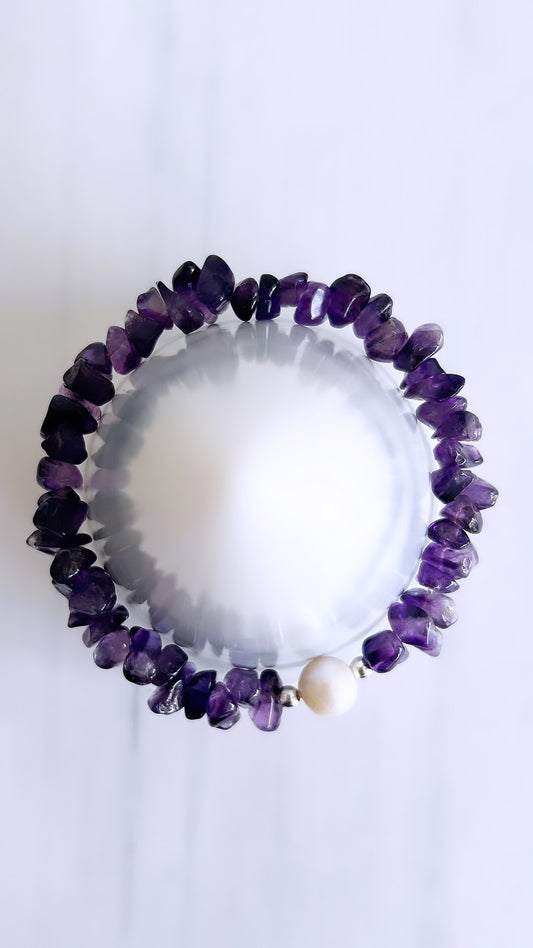 A bracelet featuring a cluster of amethyst beads with a single freshwater pearl