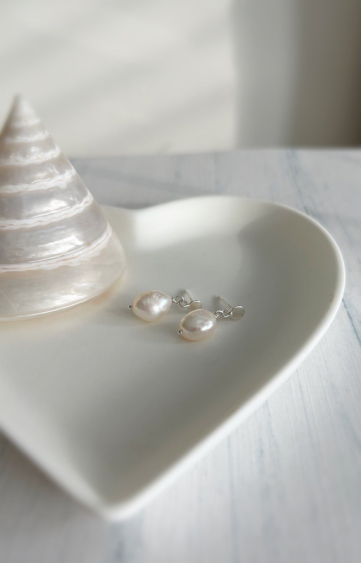 Large baroque Freshwater pearls dangling from a Sterling Silver mini disc ear stud, with butterfly clasp fastenings. The pearls measure approximately 11mm.
