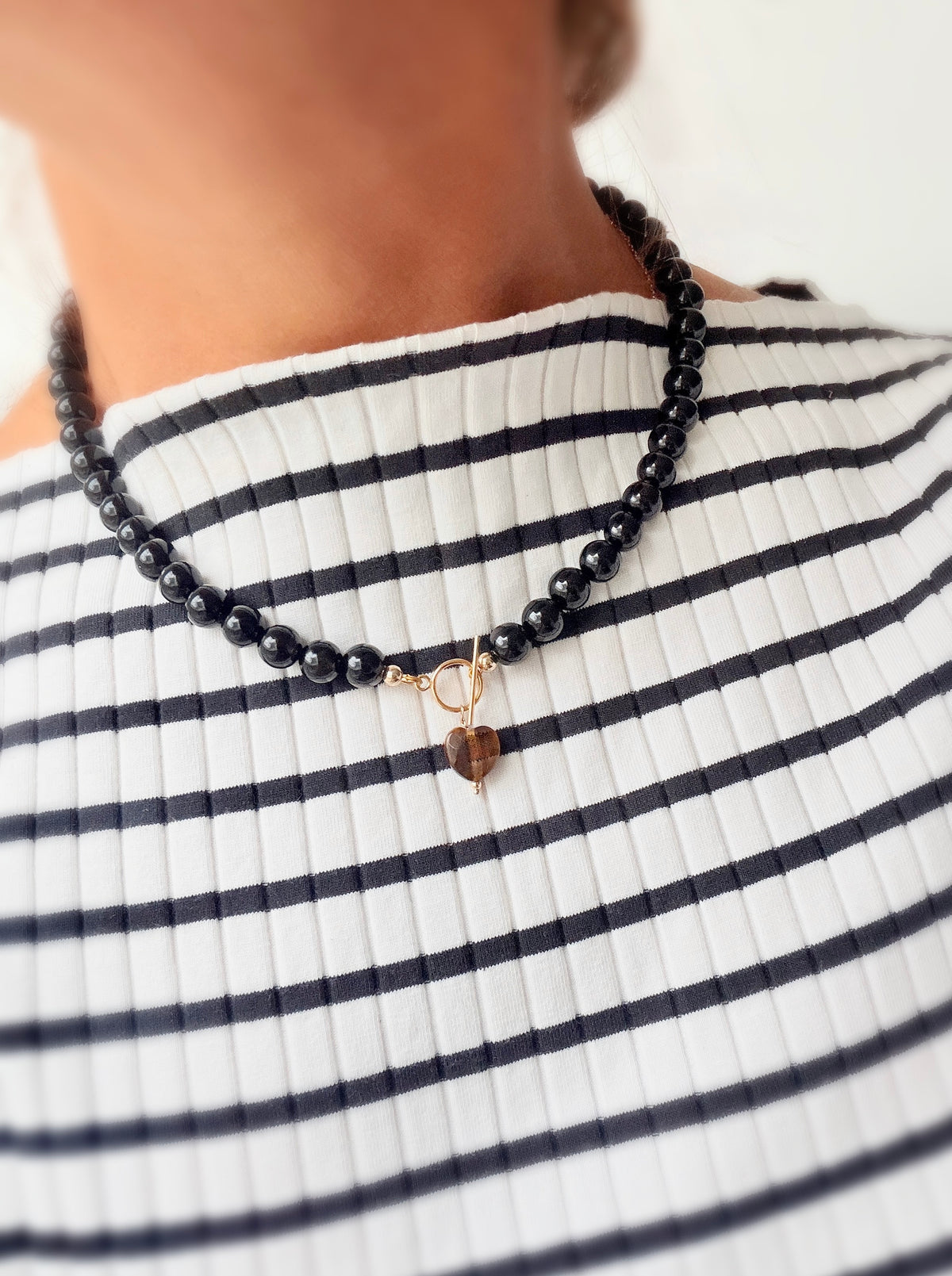 A stunning Black Onyx necklace featuring a faceted heart shaped Tiger’s Eye bead.

The necklace is finished with a toggle clasp in either a Gold filled or Sterling Silver finish. The necklace length is approximately 17”