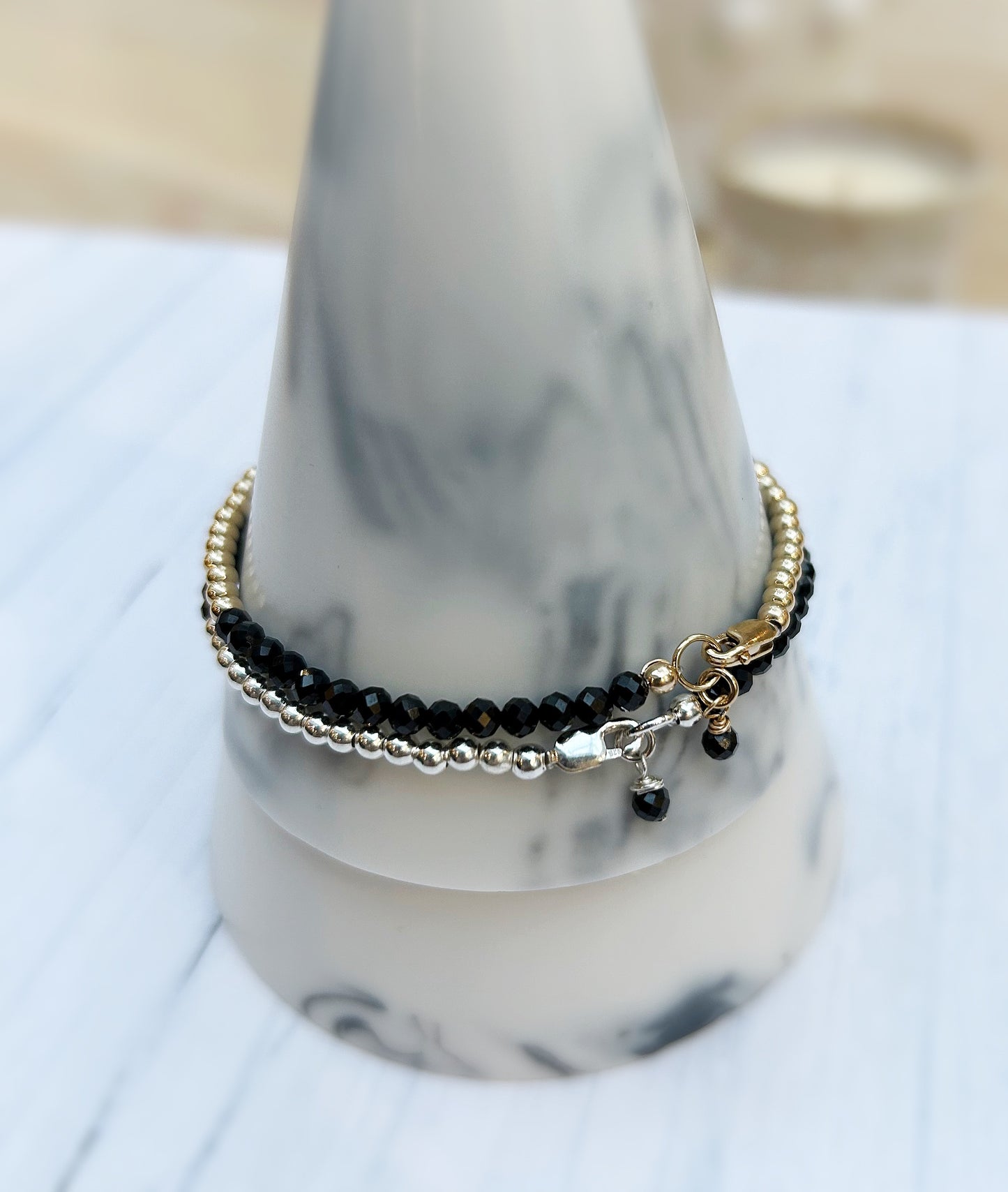 Black Spinel faceted crystal bead bracelet. This delicate bracelet comes in a choice of two finishes using either Sterling Silver or Gold Filled spacer beads and lobster closure clasp.