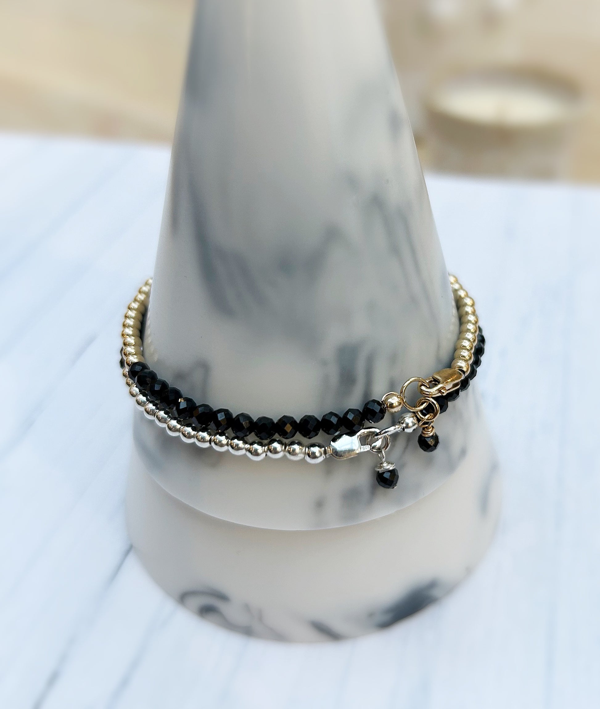 Black Spinel faceted crystal bead bracelet. This delicate bracelet comes in a choice of two finishes using either Sterling Silver or Gold Filled spacer beads and lobster closure clasp.