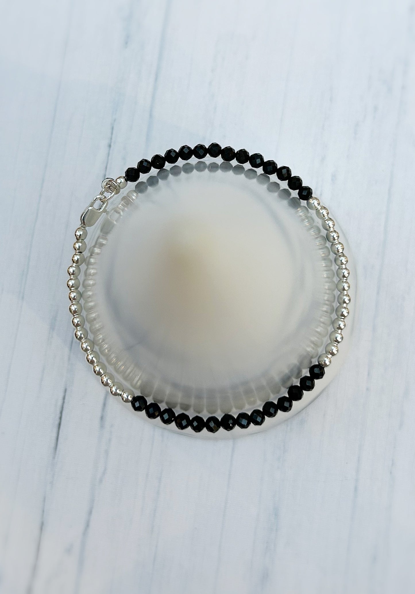Black Spinel faceted crystal bead bracelet. This delicate bracelet comes in a choice of two finishes using either Sterling Silver or Gold Filled spacer beads and lobster closure clasp.