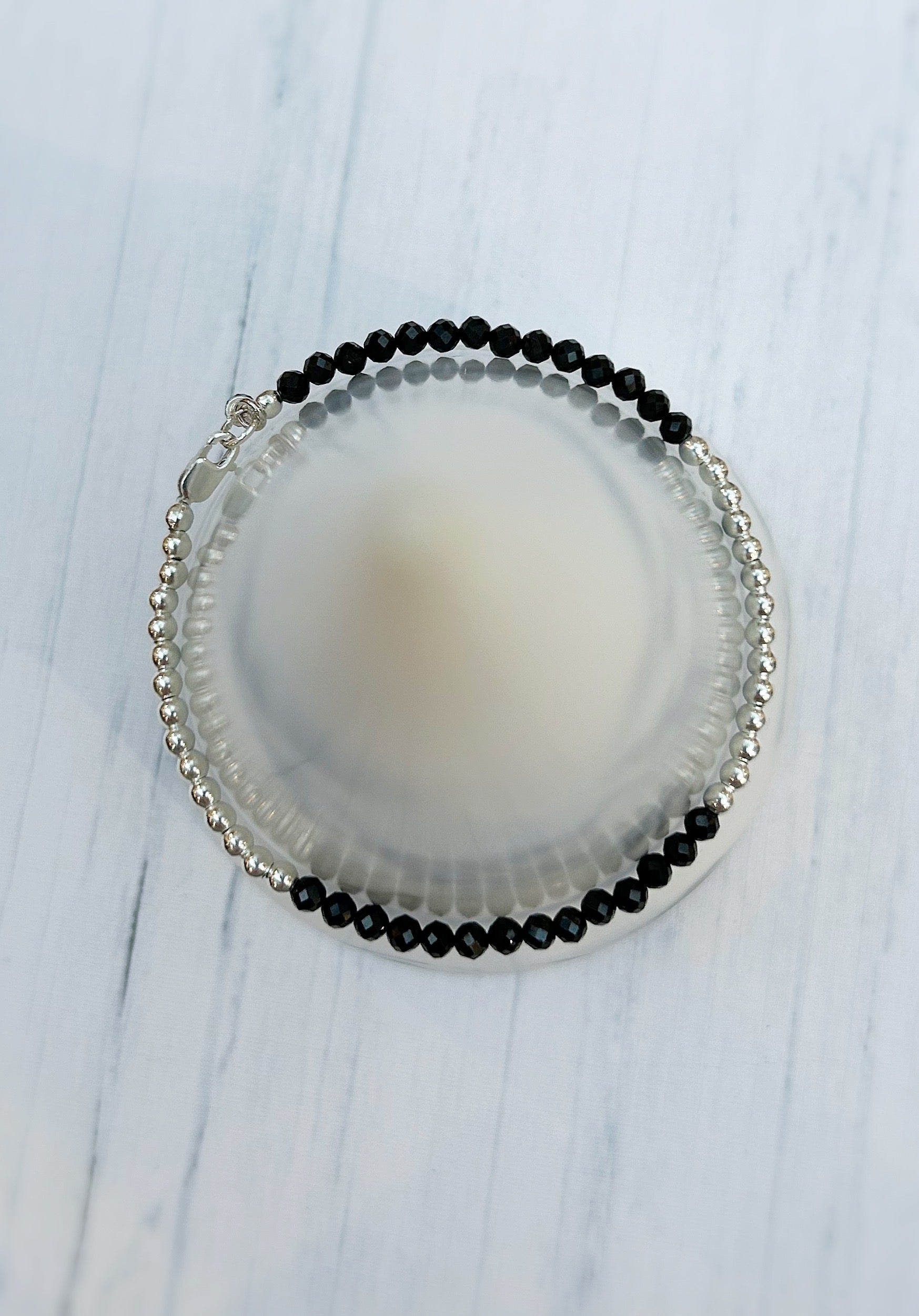 Black Spinel faceted crystal bead bracelet. This delicate bracelet comes in a choice of two finishes using either Sterling Silver or Gold Filled spacer beads and lobster closure clasp.