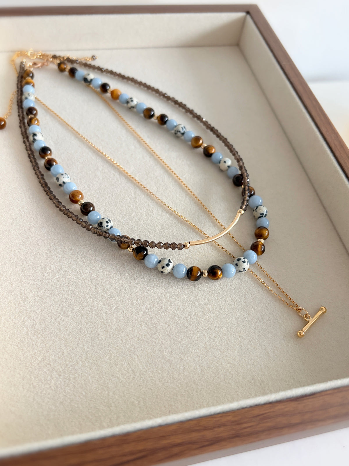 A gorgeous semi precious mixed bead necklace incorporating Angelite, Tigers Eye and Dalmatian Jasper beads, measuring 16” with a delicate clasp and 1.5” extension chain.

The necklace comes in a choice of two finishes using either Sterling Silver or Gold Filled accents
