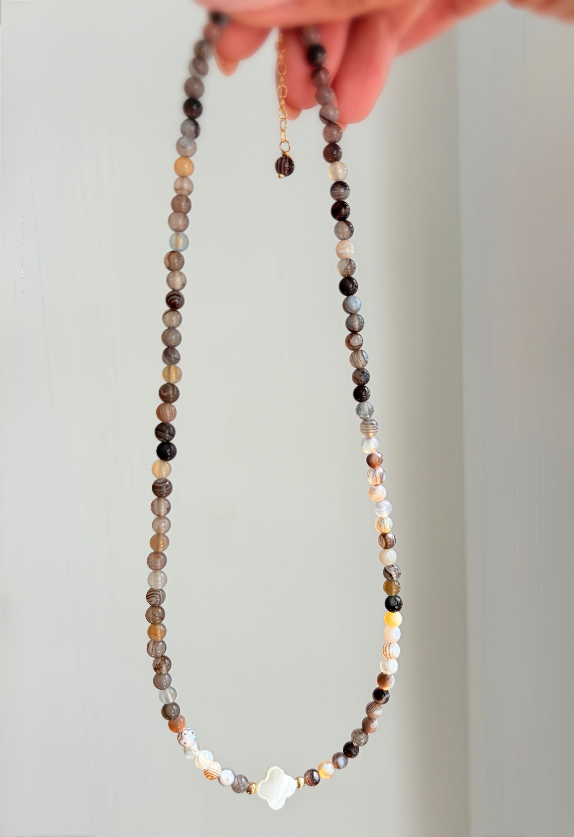 A beautiful Semi precious beaded Botswana Agate necklace with a central Mother of Pearl clover bead. 

Crafted with high quality semi precious beads, each one as beautiful as it is unique.

Available with a choice of either a Sterling Silver or Gold filled clasp. The necklace length is 16” with an 2” extender, finished at the end with a precious bead. 