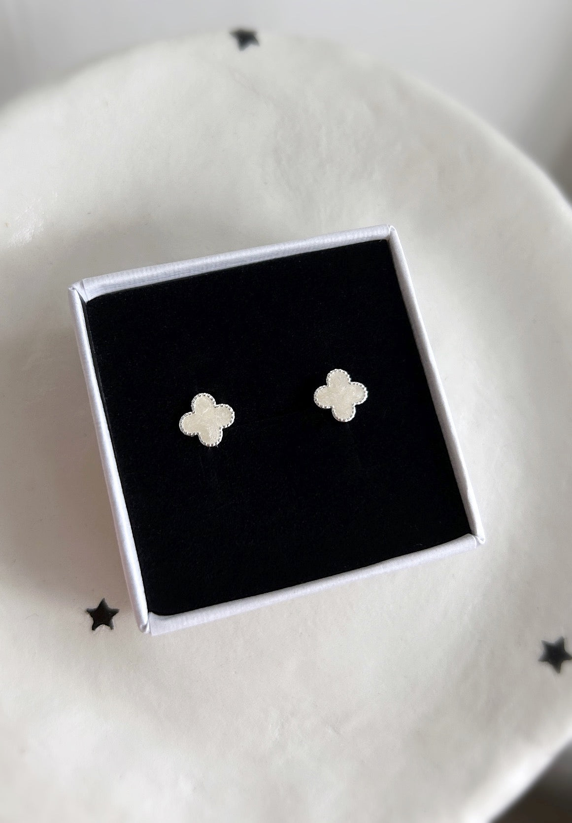 A pair of silver and mother of pearl clover stud earrings. The earrings are presented in a complimentary 'Carmina' gift box.