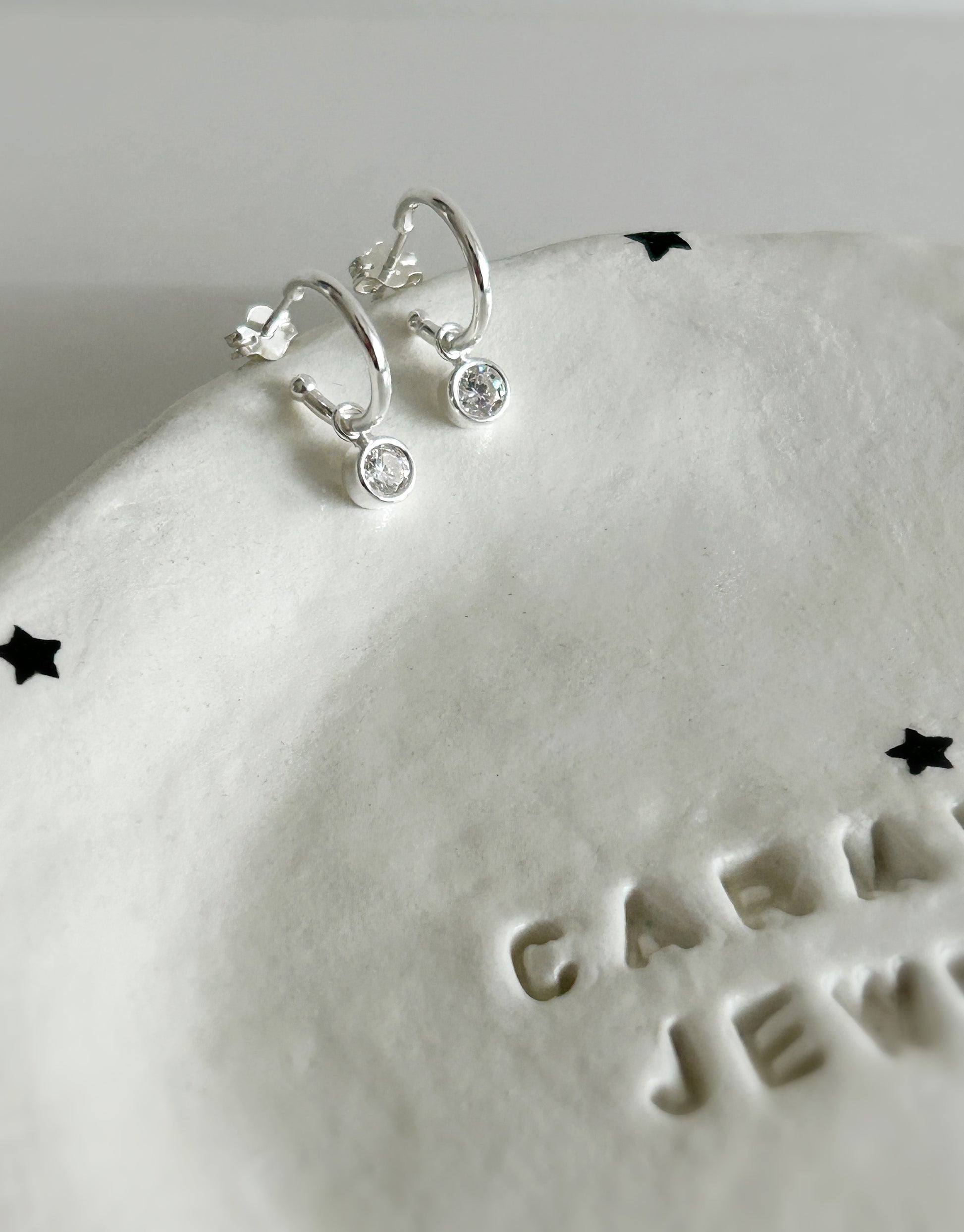 Super sparkly Cubic zirconia droplet charm earrings on a Sterling Silver hoop. 

The hoop earrings can also be worn alone as the charms can be easily removed from the hoops for a versatile earring design.