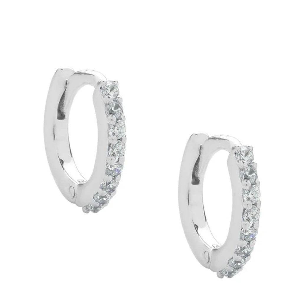 A pair of sterling silver huggie hoop earrings dotted with CZ crystals. 