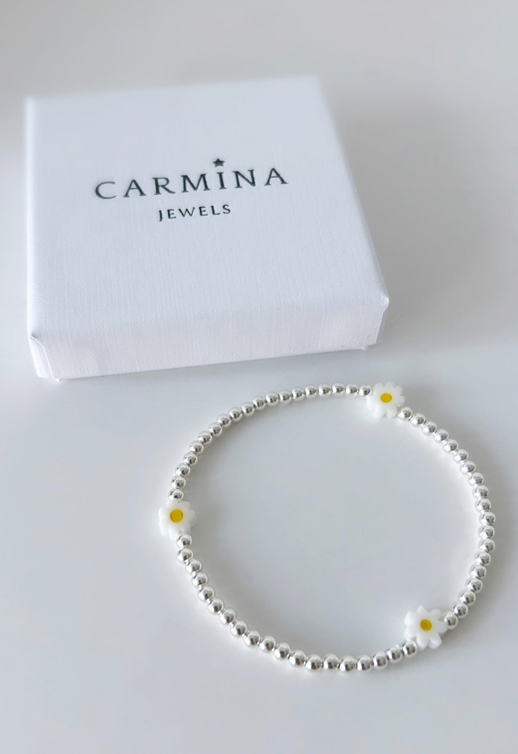 Pretty handmade Murano glass daisy bracelet with Sterling Silver round beads. The bracelet is on a stretch cord with spaced out daisies beads.