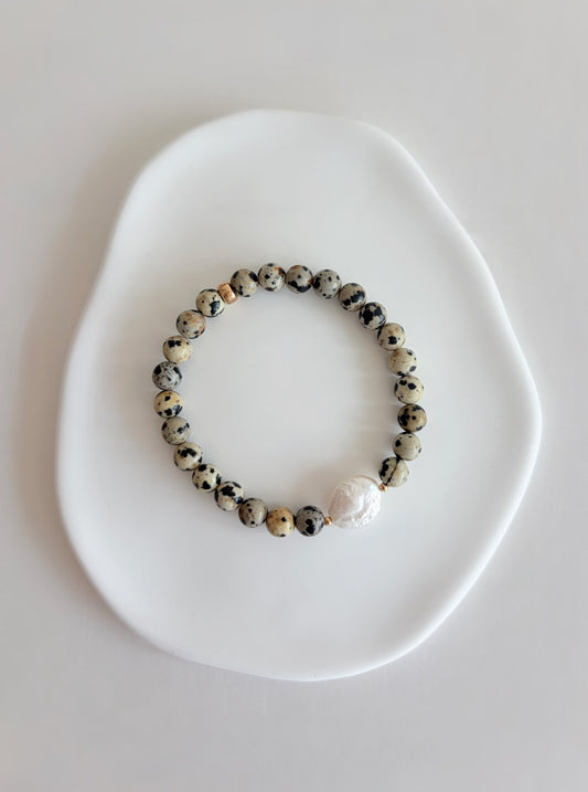A gorgeous beaded Dalmatian Jasper gemstone bracelet, with a central freshwater coin pearl, threaded on a high quality stretch cord.