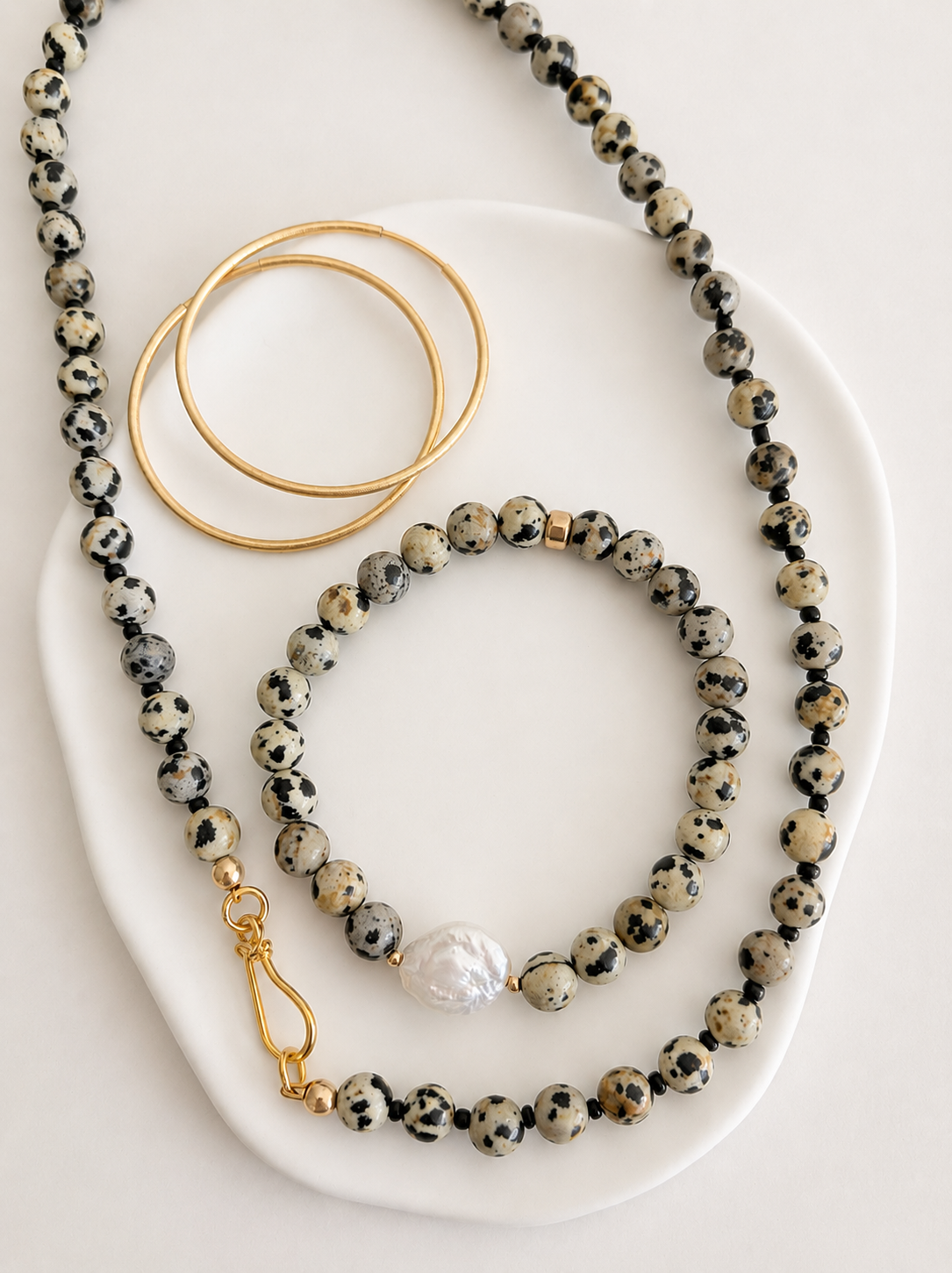This gorgeous beaded necklace is the perfect accessory for any season. Made using semi precious Dalmatian Jasper beads.   

The necklace is finished with a decorative ‘S’ style clasp fastener in either a Gold Vermeil or Sterling Silver finish. The necklace length is 18”.
