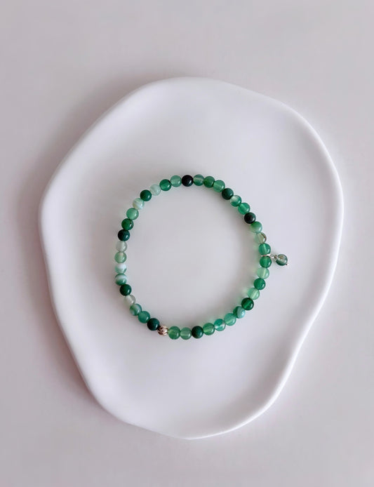 A beautiful semi precious beaded Green Agate stacking bracelet accented with a Sterling Silver twist engraved bead and an agate dangle bead, hand threaded on a durable stretch cord.
