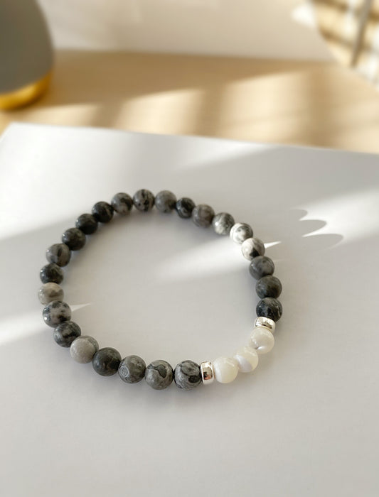 A beaded bracelet with a mix of grey jasper and mother of pearl beads, finished with sterling silver doughnut spacer beads