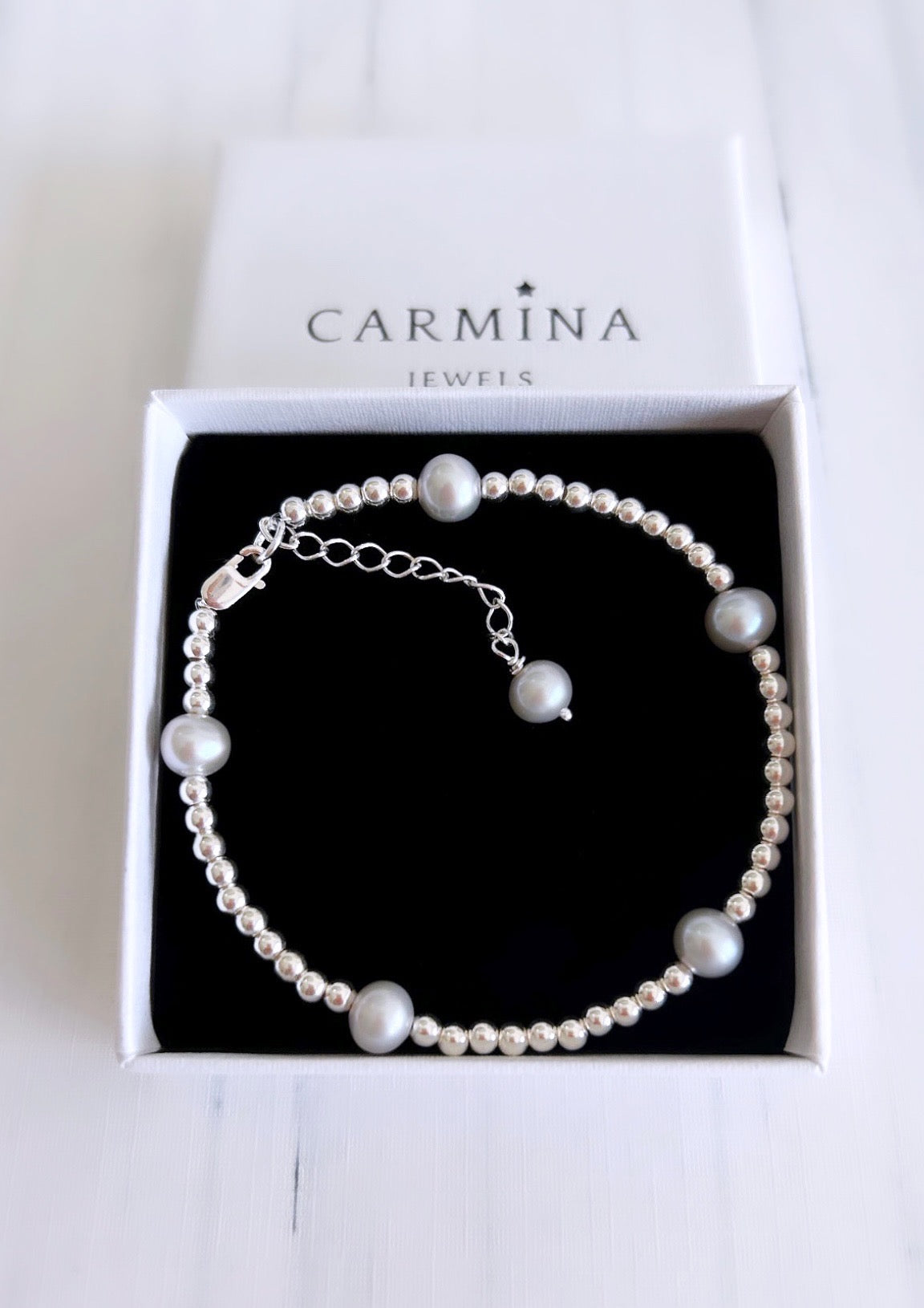 A grey baroque freshwater pearl bracelet with sterling silver beads, presented in a Carmina branded gift box.