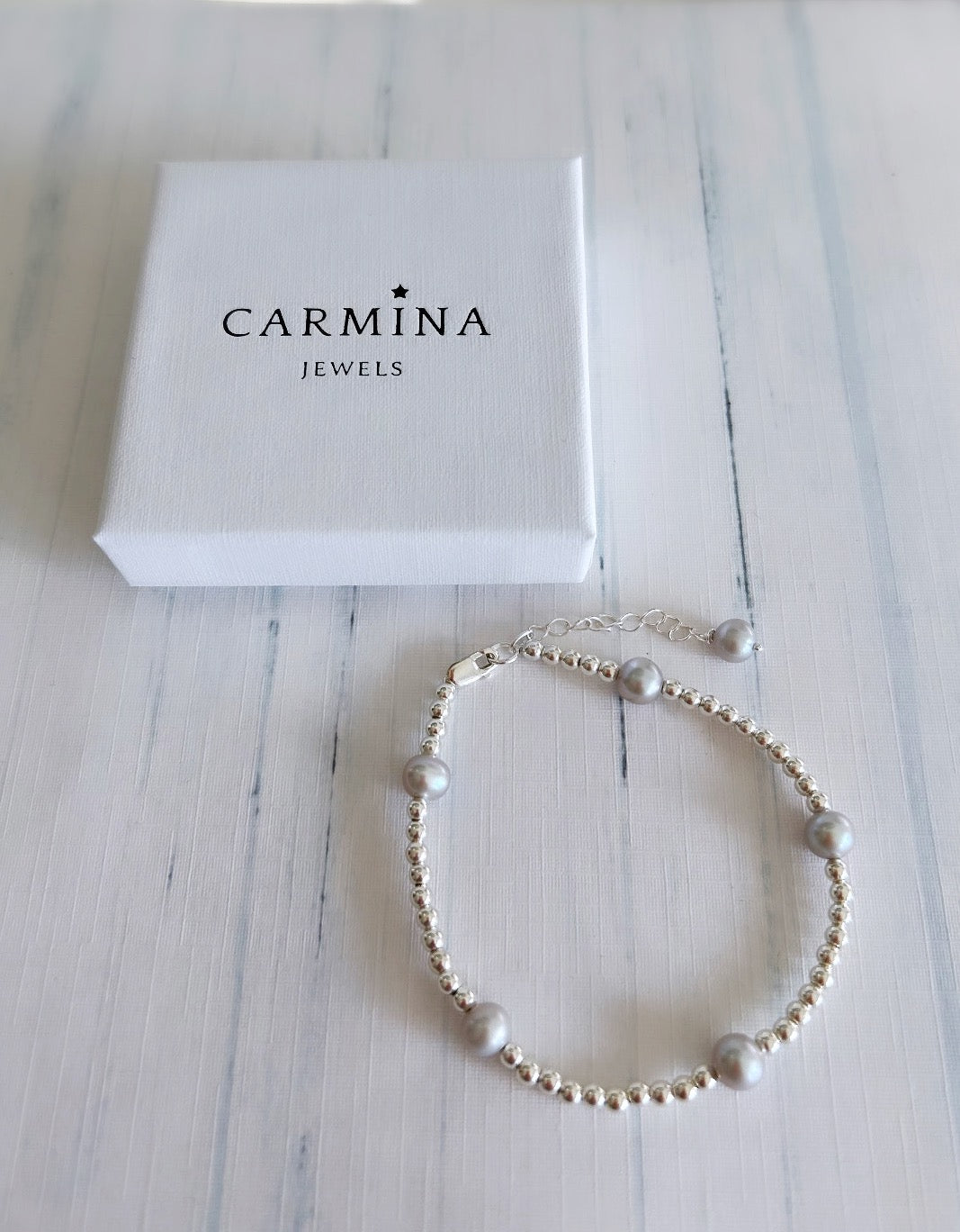 An elegant Grey baroque Freshwater Pearl bracelet, with Sterling Silver beads. This delicate bracelet is finished with a Sterling Silver lobster closure clasp, and extension chain with a Pearl at its end. 