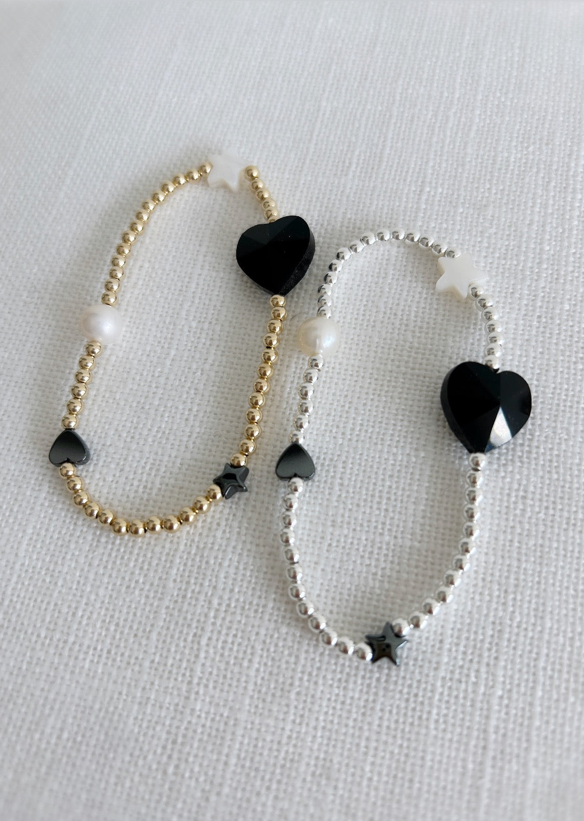 A beautiful stacking bracelet adorned with a charming mix of hearts, stars, and pearls ~ featuring a glass heart bead, a freshwater pearl, a Mother of Pearl heart and star, and a shimmering hematite star.