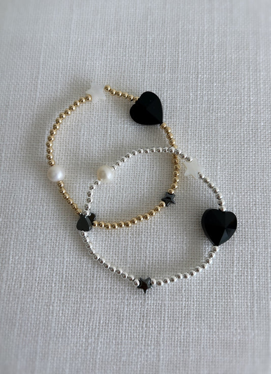 A beautiful stacking bracelet adorned with a charming mix of hearts, stars, and pearls ~ featuring a glass heart bead, a freshwater pearl, a Mother of Pearl heart and star, and a shimmering hematite star.