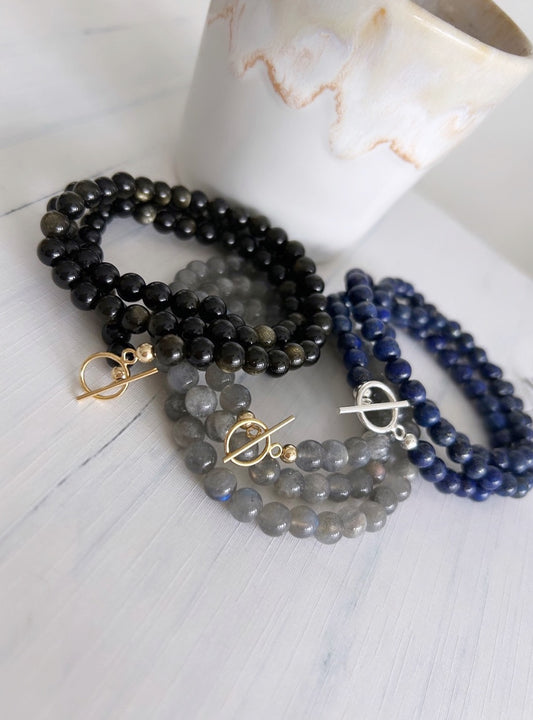 A gorgeous ‘2 in 1’ Semi Precious beaded wrap bracelet &/or necklace in a choice of either beautiful Smoky Quartz, Lapis Lazuli, Labradorite or Golden Obsidian. Finished with a delicate toggle clasp in Gold filled or Sterling Silver. 
