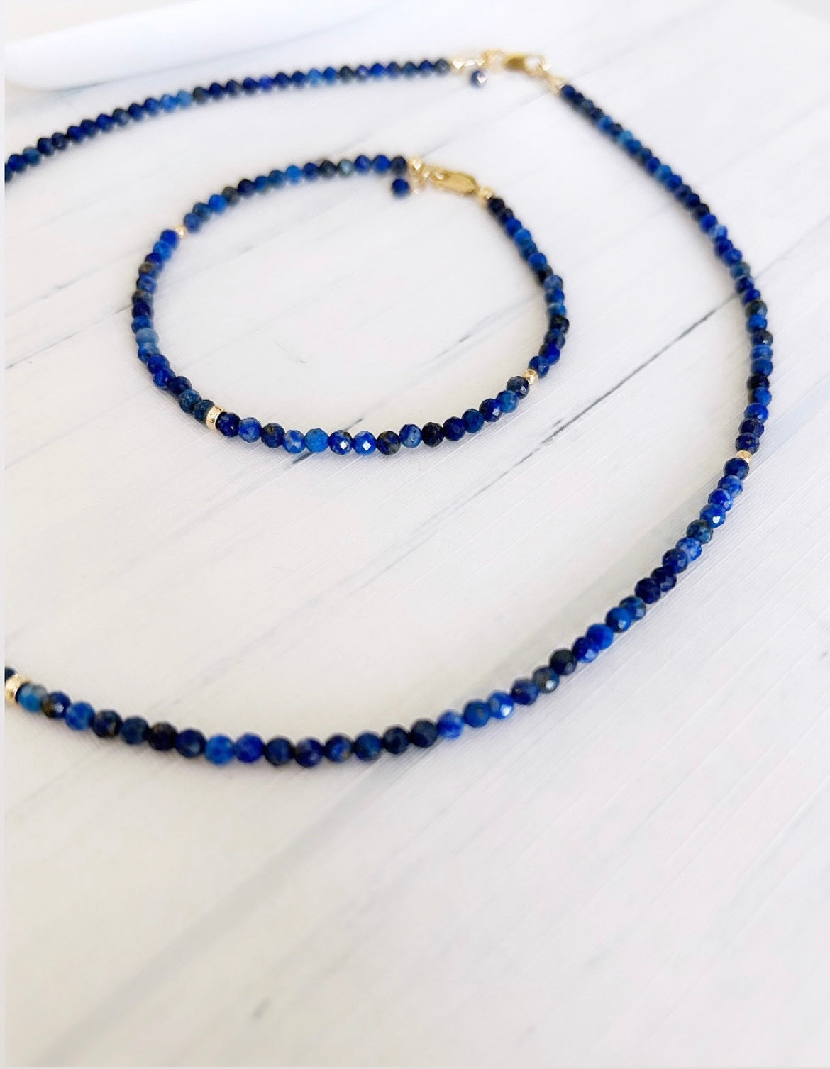 A looped lapis lazuli bead necklace with gold filled spacer beads and a lobster closure clasp