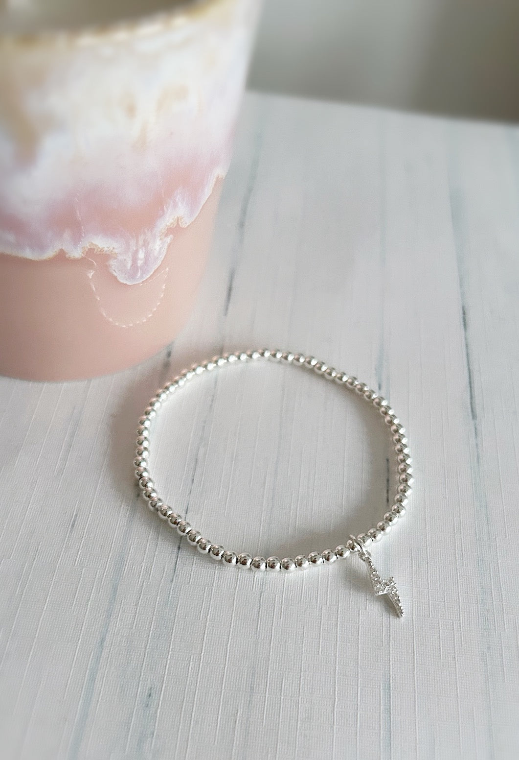 A sterling silver bracelet with a lightning bolt charm