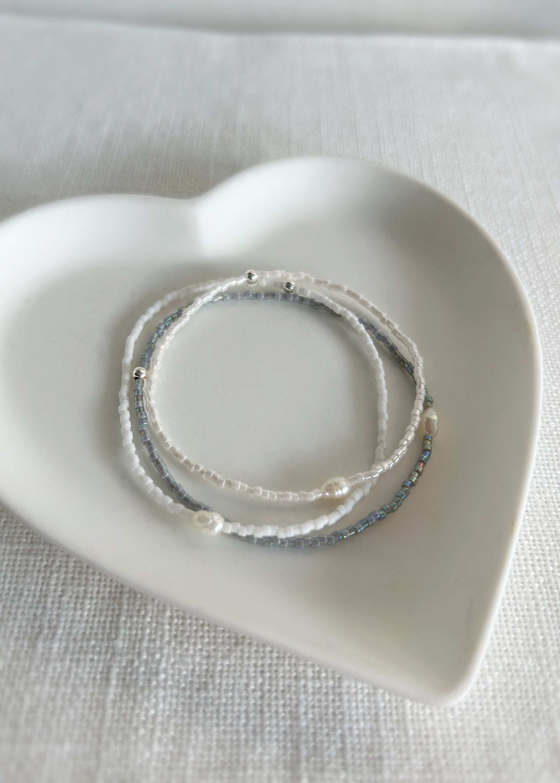 Delicate Miyuki glass beaded bracelets, in a choice of Pearlescent white, grey or matte white, with a beautiful Freshwater rice Pearl. 

These dainty mini bracelets are perfect little stackers! 