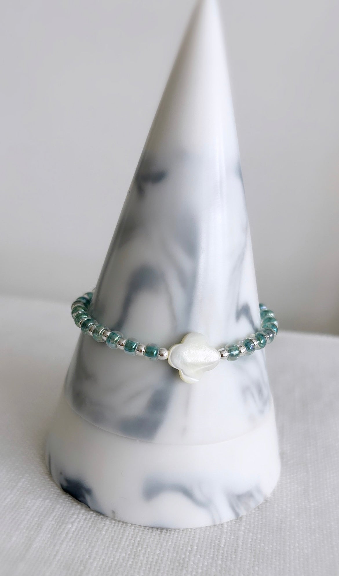 Mother of Pearl clover charm bracelet with Sterling silver and sea blue lined crystal glass miyuki beads on a strong stretch cord 