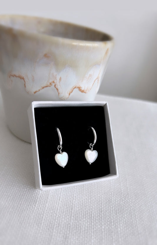 Mother of pearl puffed heart shaped bead dangle earrings on a Sterling Silver hoop. The heart pearls are an off white colour with a beautiful pearlescent lustre.