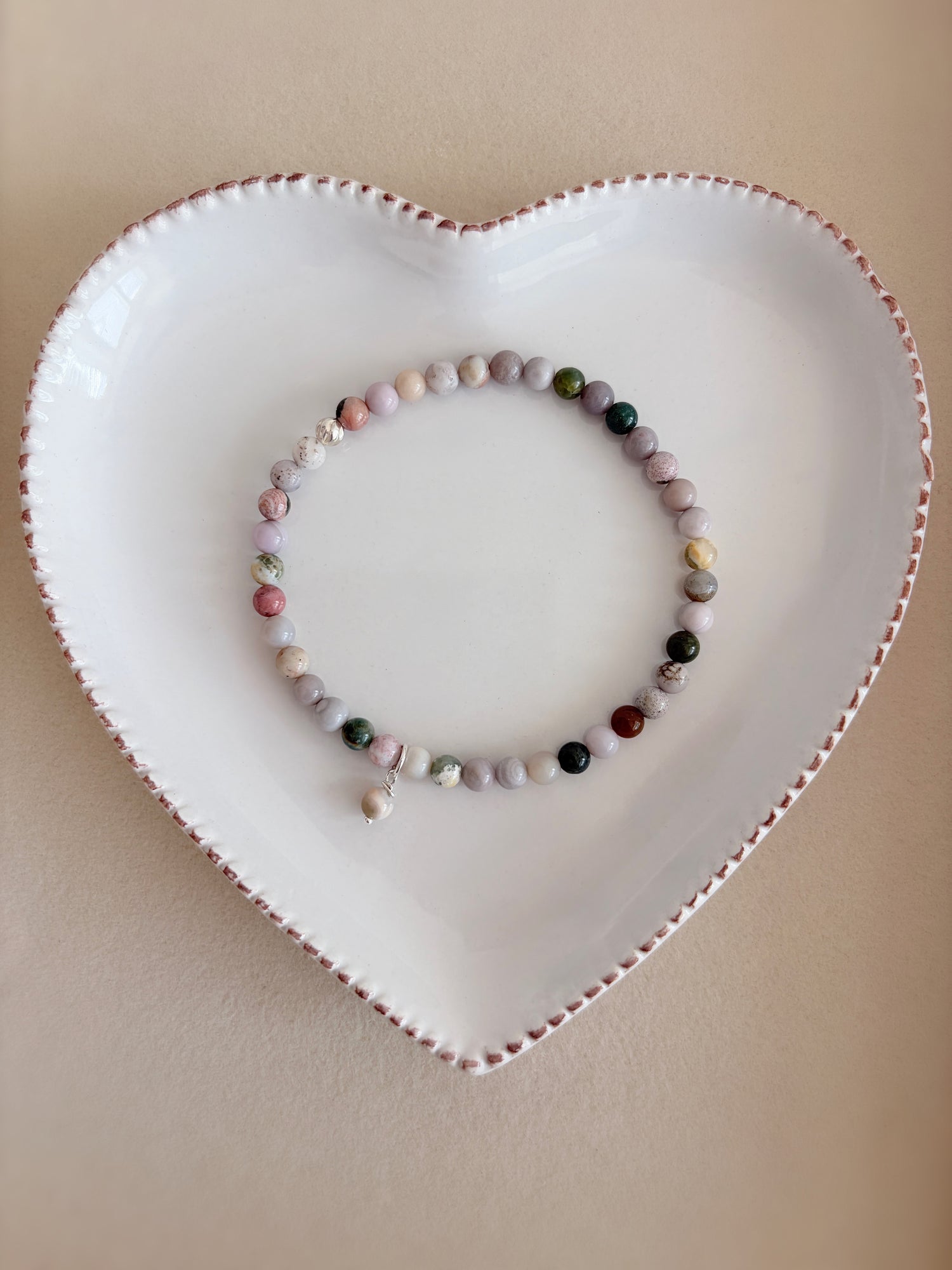 A beautiful semi precious beaded Ocean Jasper stacking bracelet accented with a Sterling Silver twist engraved bead and a Jasper dangle bead, hand threaded on a durable stretch cord.
