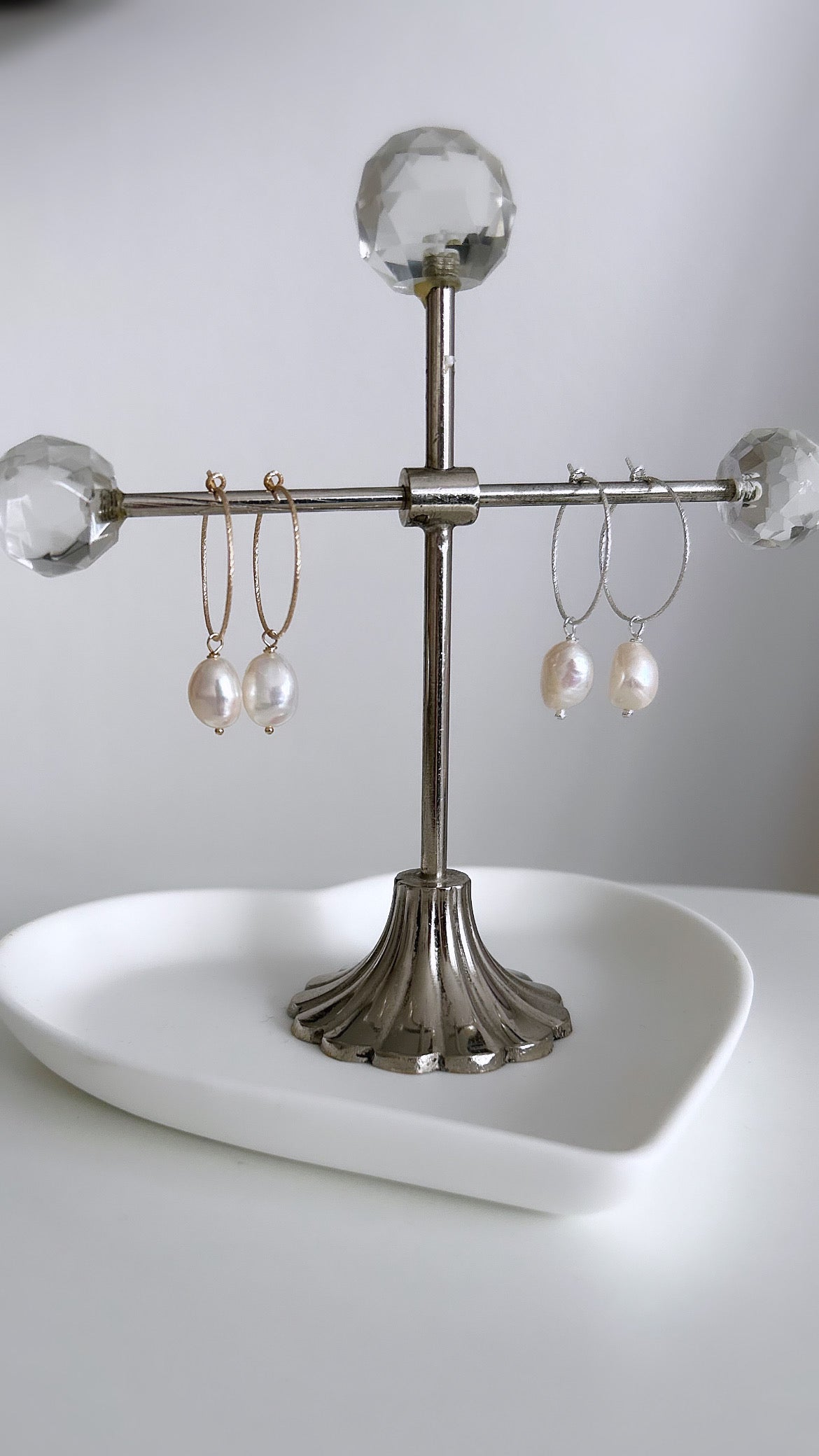 A pair of silver or gold hoop earrings with fresh water pearls.