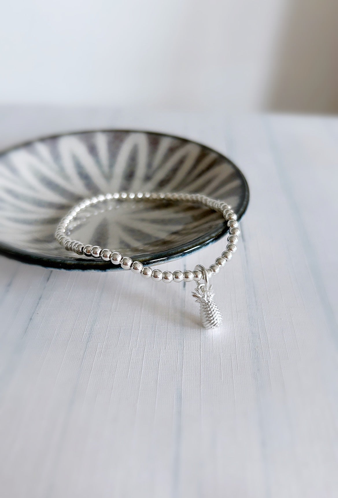 A sterling silver bracelet with a pineapple charm
