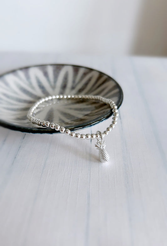 A sterling silver bracelet with a pineapple charm