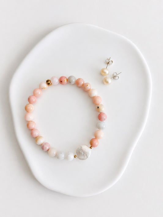 A beautiful Pink opal semi precious beaded bracelet with a central freshwater coin pearl, threaded on a high quality stretch cord.