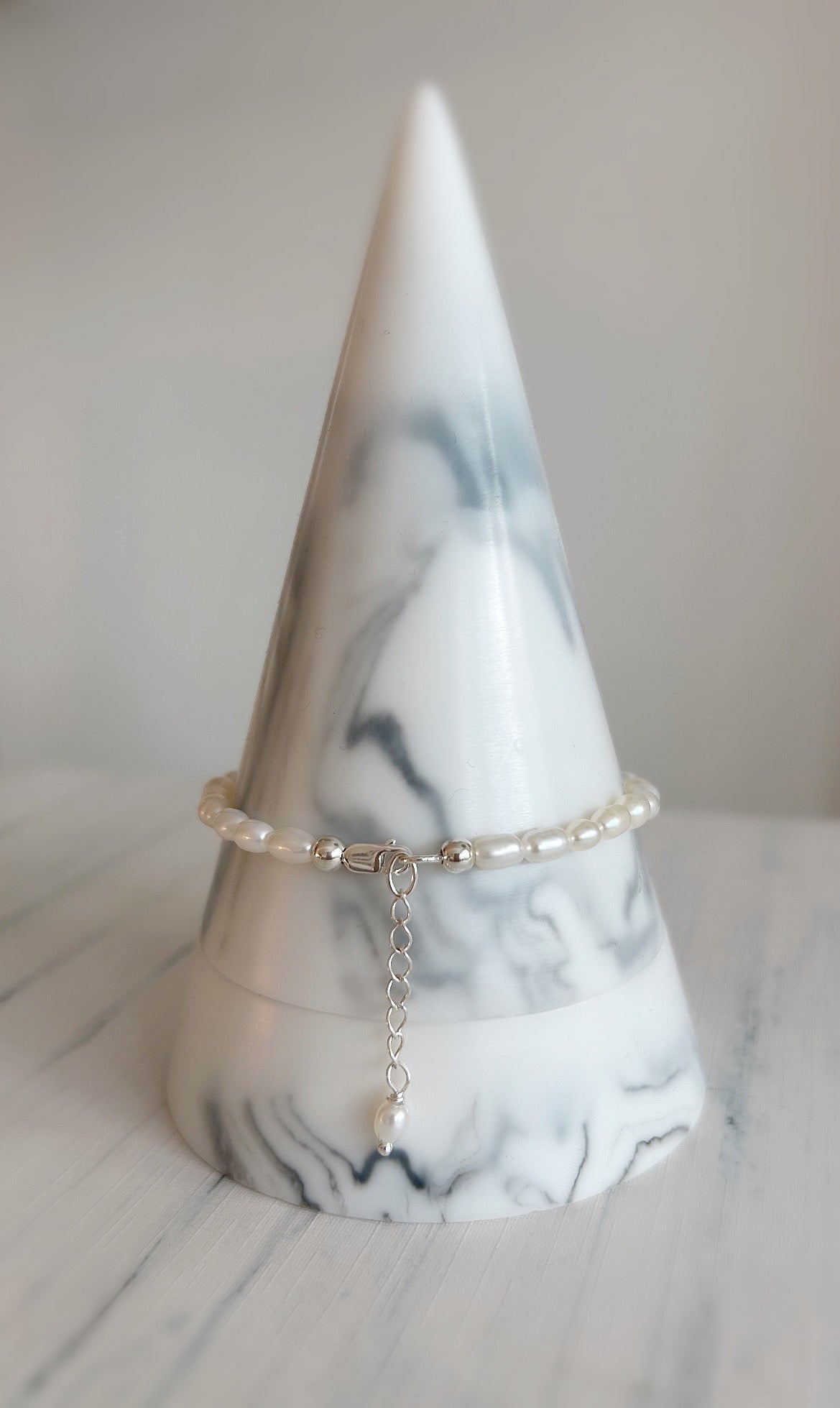 A elegant Freshwater Rice Pearl bracelet finished with a Sterling Silver or Gold Filled lobster clasp, and delicate extension chain with a Pearl at its end