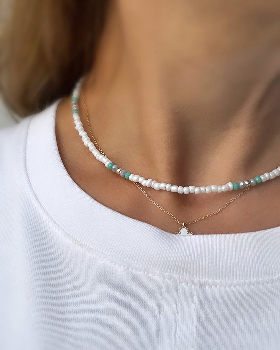 a seed bead necklace featuring aqua and pale grey crystal glass beads, with gold/silver spacer beads and a gold-filled fastening lobster clasp.