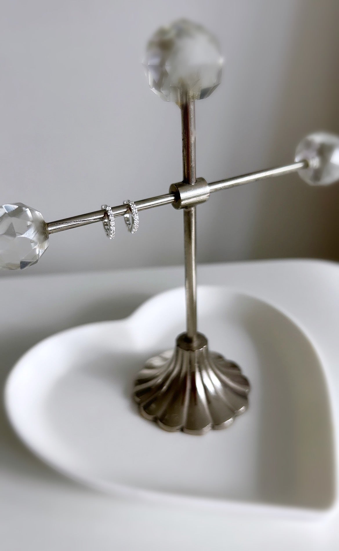 A pair of sterling silver huggie hoop earrings dotted with CZ crystals. 