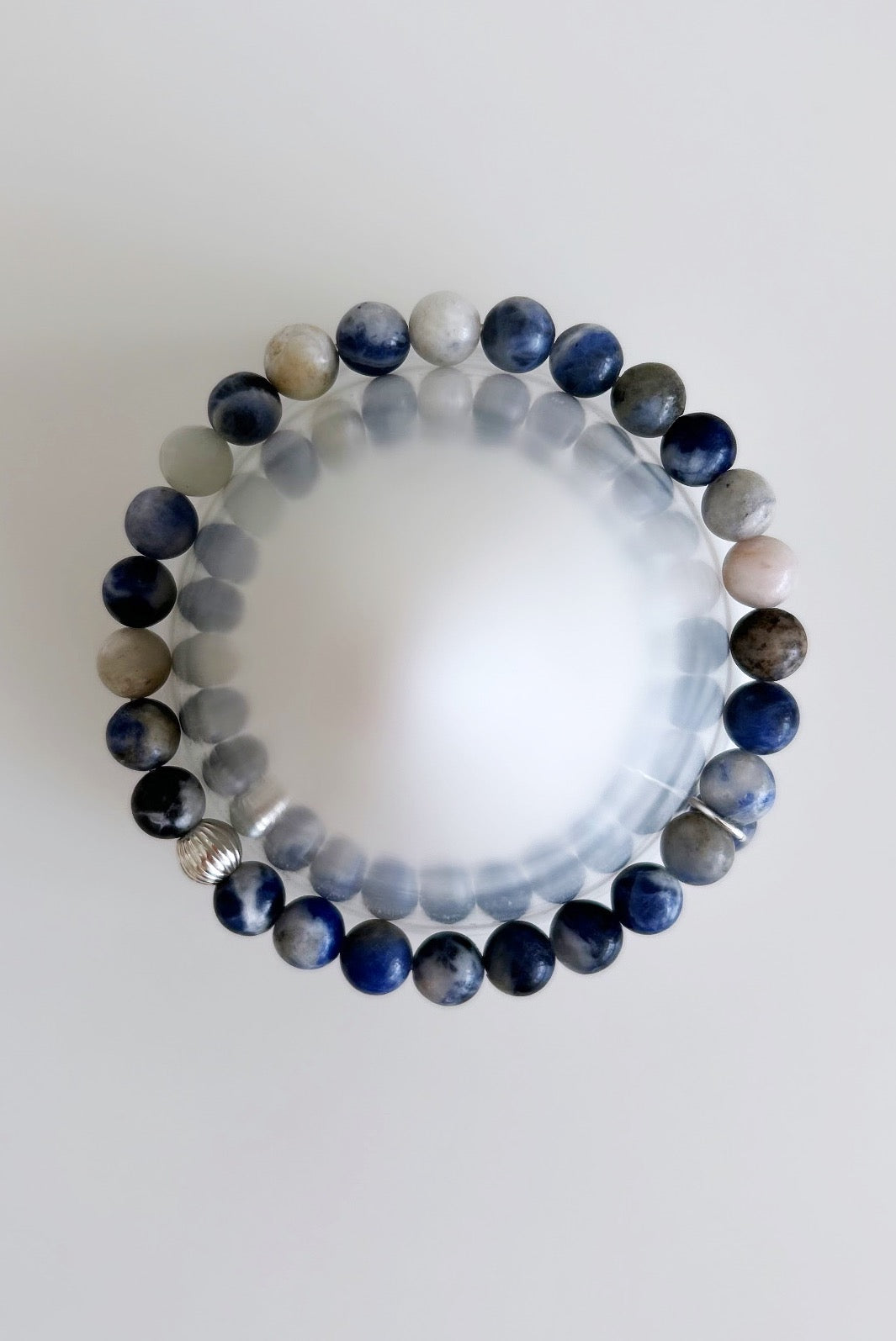A sodalite beaded bracelet with a silver corrugated spacer bead and a sodalite dangle bead
