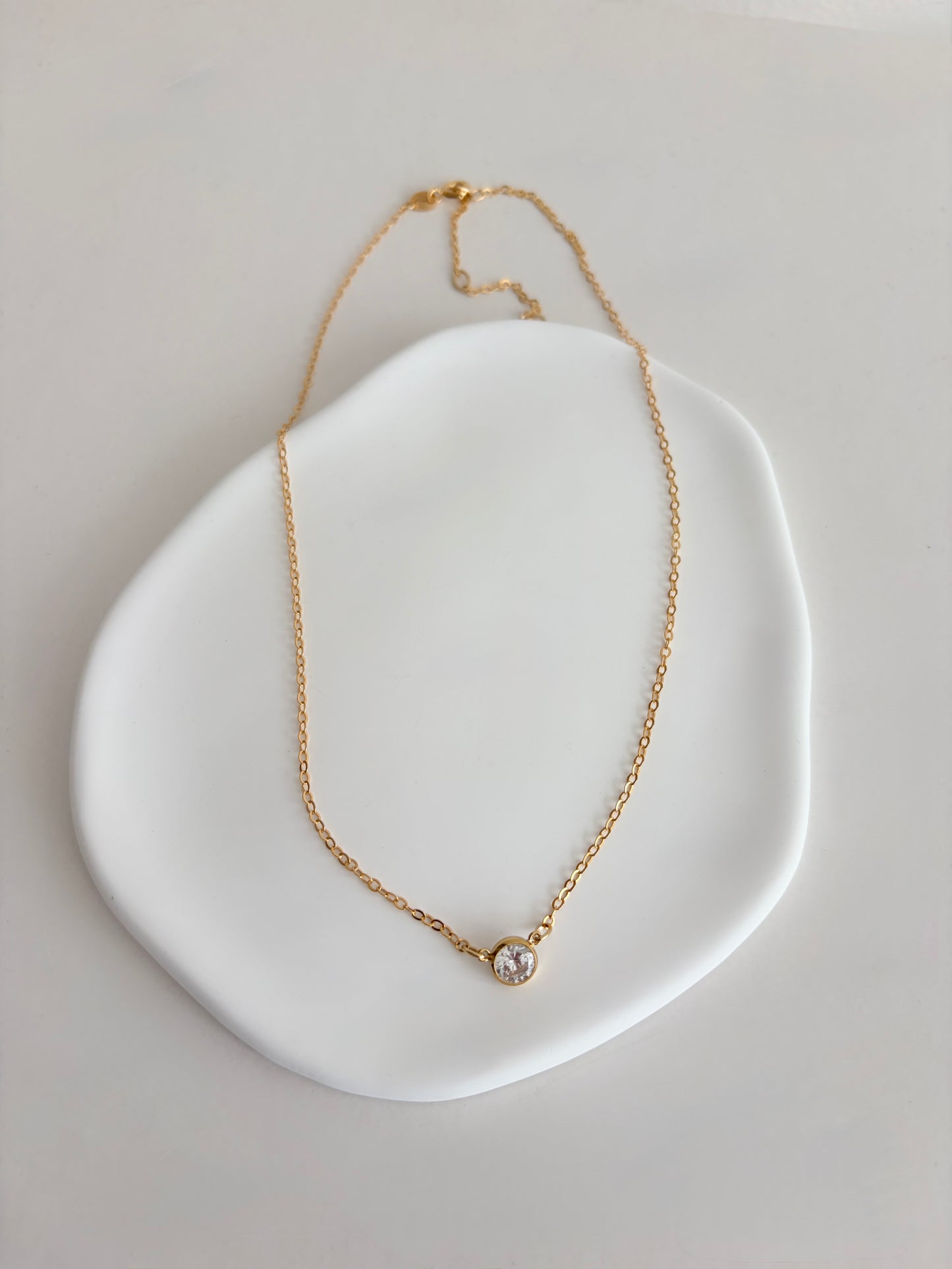 A super sparkly Cubic Zirconia choker style necklace on a 14” gold filled chain, with a 2” extender. The necklace sits just in the nape of the neck and is therefore a perfect necklace for layering up with longer chains.

The beautiful brilliant white CZ stone measures 9.5mm.