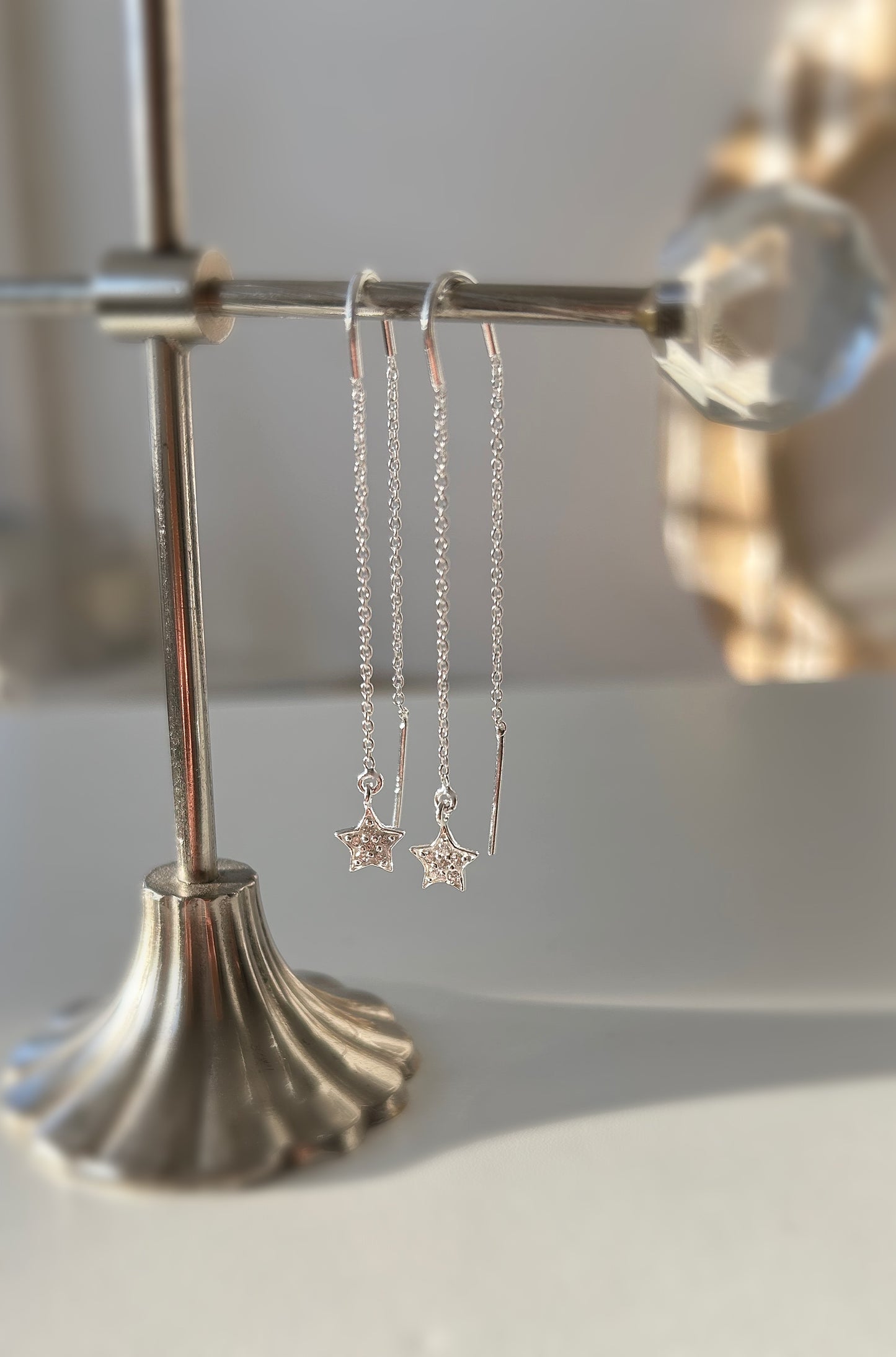 A pair of sterling silver threader earrings with cubic zirconia star charms
