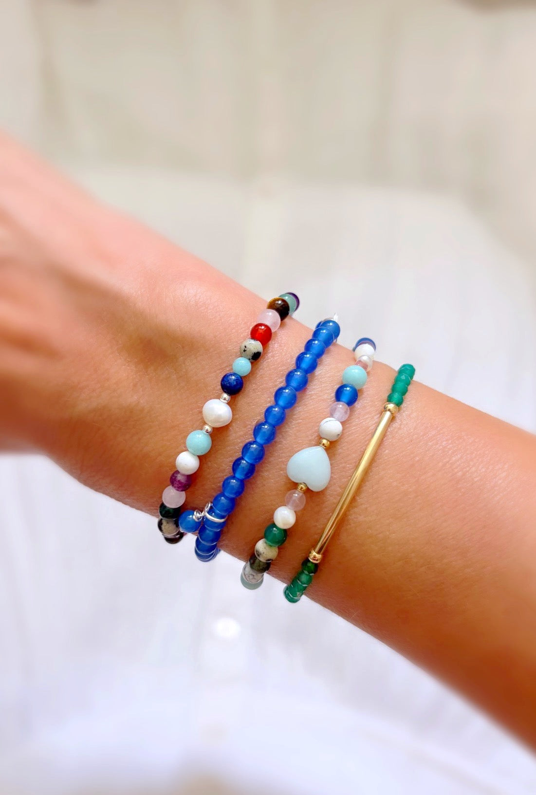 Featuring a glorious mix of vibrant semi precious beads, this beautiful bracelet is designed to add a touch of colour and elegance to any outfit. Choose between a charming Amazonite heart bead or an elegant baroque freshwater pearl as the centre.