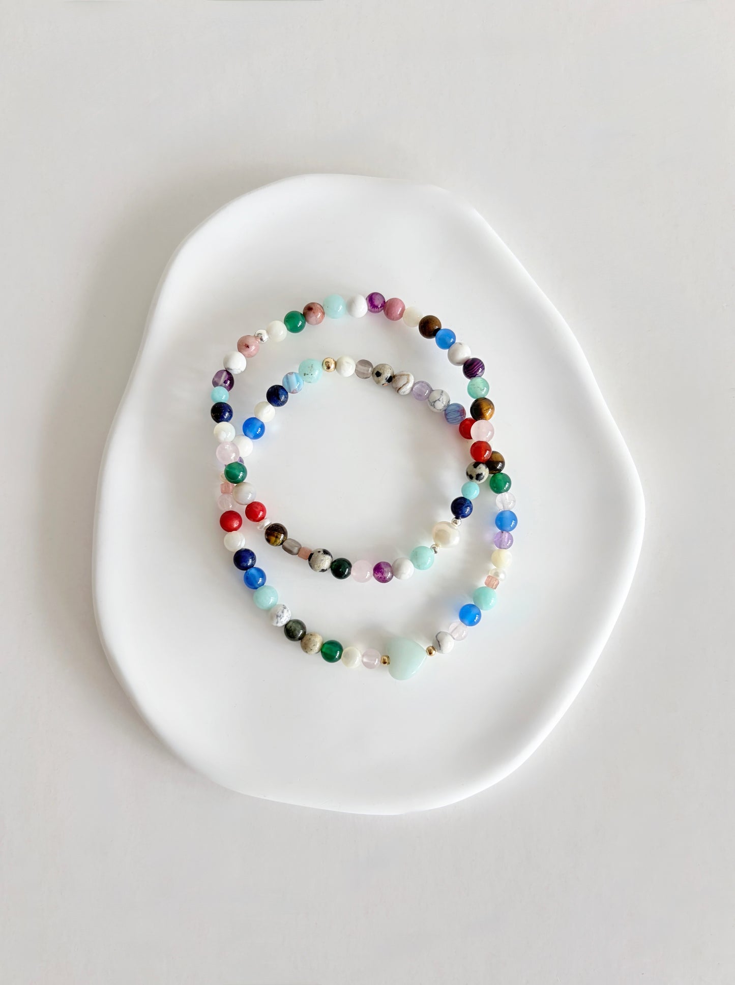 Featuring a glorious mix of vibrant semi precious beads, this beautiful bracelet is designed to add a touch of colour and elegance to any outfit. Choose between a charming Amazonite heart bead or an elegant baroque freshwater pearl as the centre.