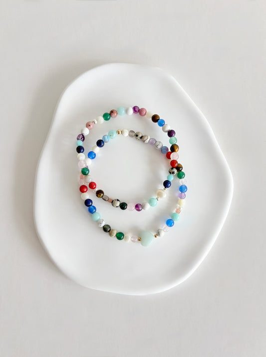 Featuring a glorious mix of vibrant semi precious beads, this beautiful bracelet is designed to add a touch of colour and elegance to any outfit. Choose between a charming Amazonite heart bead or an elegant baroque freshwater pearl as the centre.