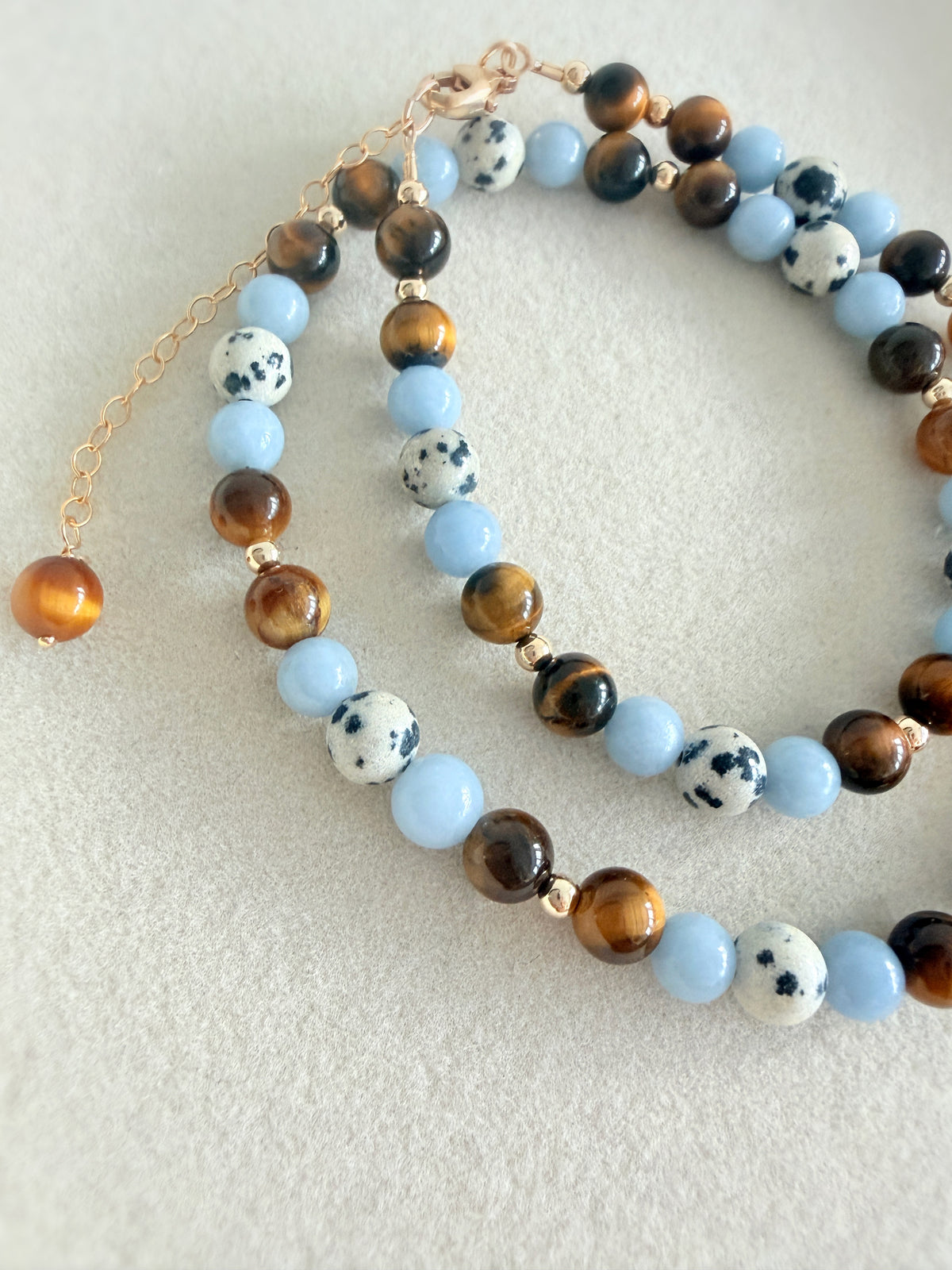 A gorgeous semi precious mixed bead necklace incorporating Angelite, Tigers Eye and Dalmatian Jasper beads, measuring 16” with a delicate clasp and 1.5” extension chain.

The necklace comes in a choice of two finishes using either Sterling Silver or Gold Filled accents