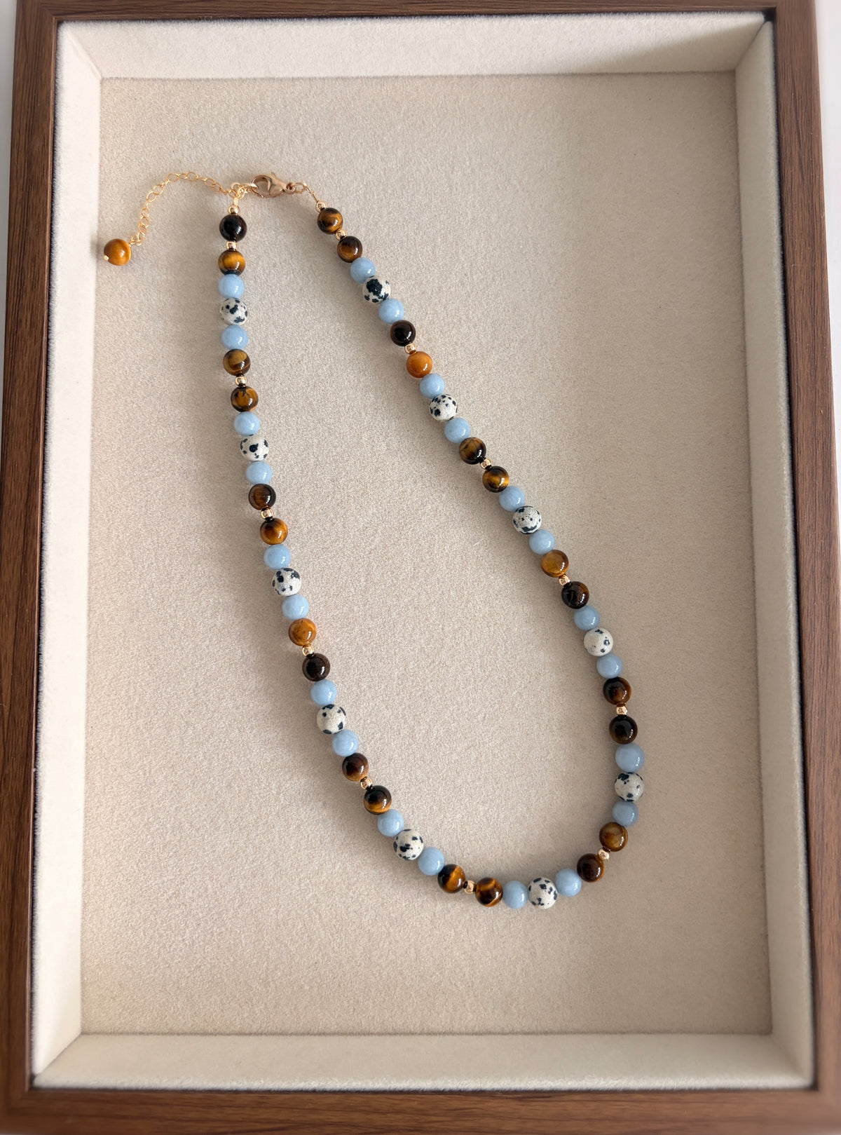 A gorgeous semi precious mixed bead necklace incorporating Angelite, Tigers Eye and Dalmatian Jasper beads, measuring 16” with a delicate clasp and 1.5” extension chain.

The necklace comes in a choice of two finishes using either Sterling Silver or Gold Filled accents