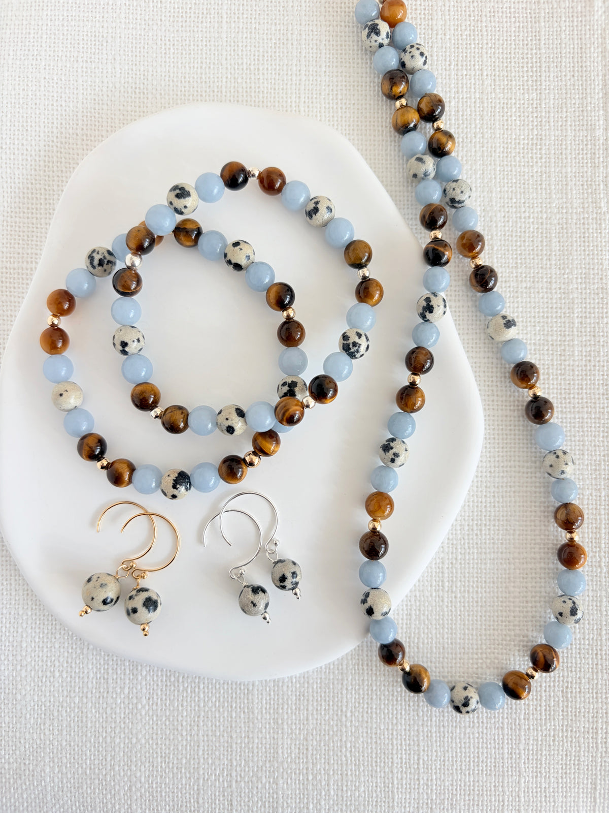 A gorgeous semi precious mixed bead necklace incorporating Angelite, Tigers Eye and Dalmatian Jasper beads, measuring 16” with a delicate clasp and 1.5” extension chain.
