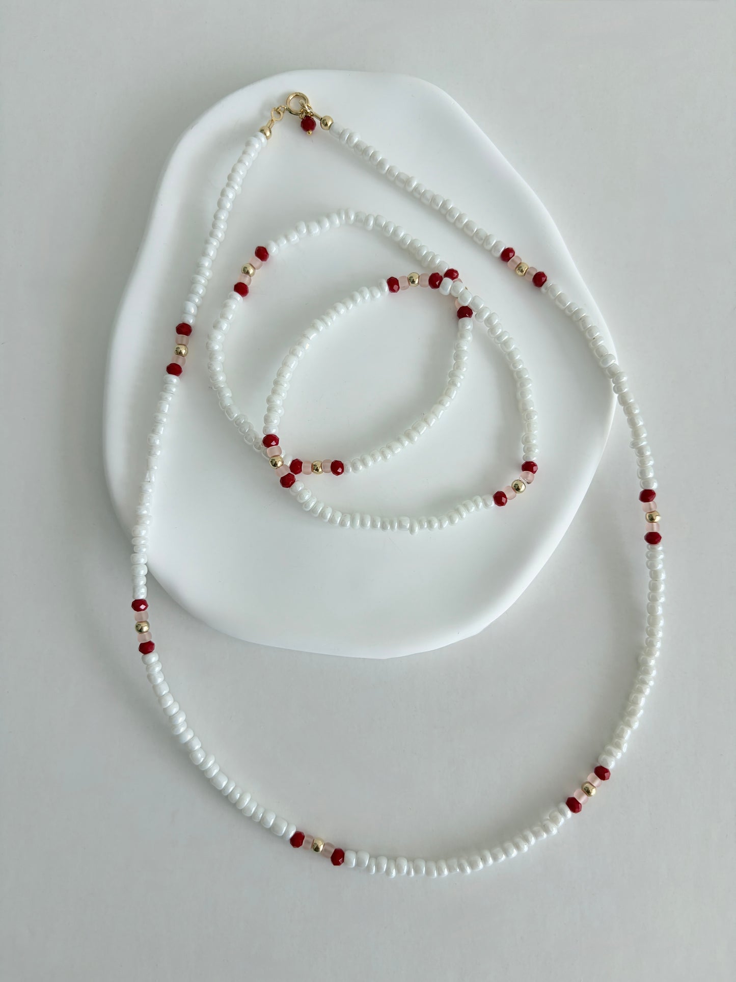 Pretty lustred glass seed bead Necklace, mixed with a subtle pattern of either aqua & pale grey or red/pink crystal glass beads and gold/silver spacer beads. The necklace will be finished with a Gold Filled or Sterling Silver fastening lobster clasp. A perfect necklace for layering with other chains or pendants.
